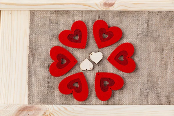 Heart on a wooden background covered with burlap, a card for Valentine 's Day . — стоковое фото