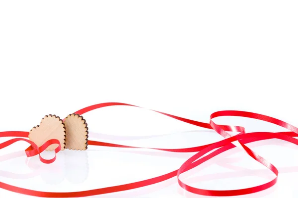 Two hearts. Two wooden hearts and festive red ribbon on a white background, Valentine's Day. Celebration background