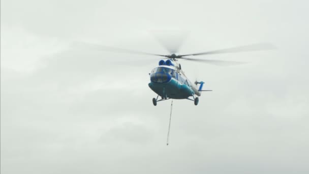 Вертолет летит с стропами для груза — стоковое видео