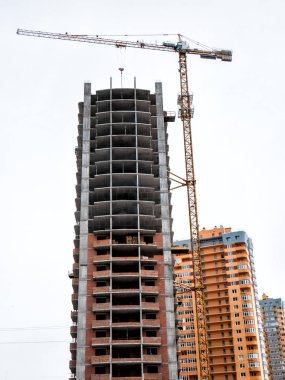 Beyaz zemin üzerine bina inşaat yakınındaki vinç.