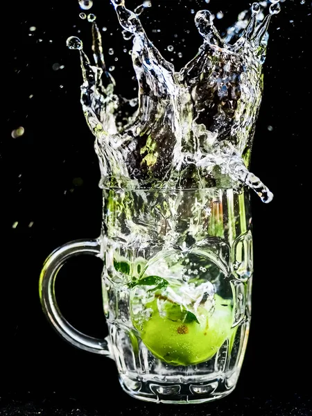 Vodní splash makrofotografie Cherry jak to vrhá do sklenice vody. — Stock fotografie
