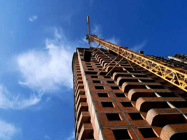 Grúa de construcción cerca de la construcción sobre fondo azul cielo . — Foto de Stock