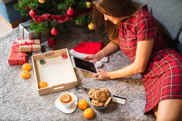 Mujer sosteniendo la tableta con espacio en blanco y tarjeta de crédito tirada en el suelo. concepto de compras de Navidad — Foto de Stock