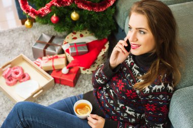 Genç gülümseyen kadın ile bir telefon. Noel zamanı