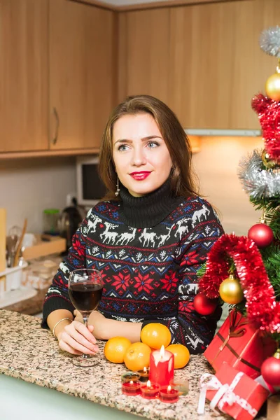 Junge glückliche Frau mit einem Glas Wein in der Nähe des Weihnachtsbaums — Stockfoto