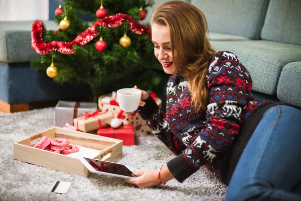 Junge Frau mit Kreditkarte und Tablet an Weihnachten — Stockfoto