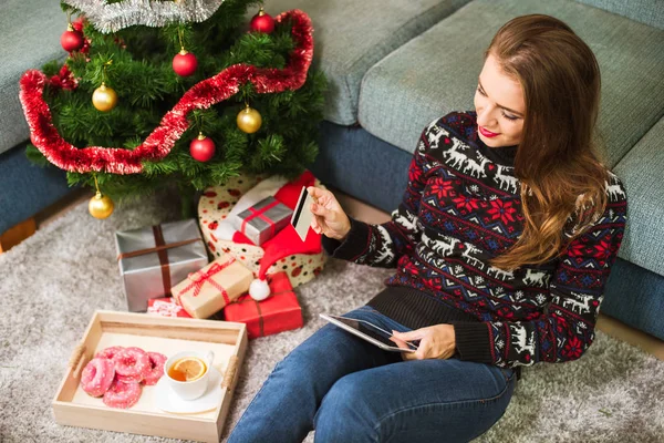Junge Frau mit Kreditkarte und Tablet an Weihnachten — Stockfoto