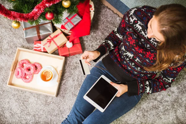 Kredi kartı ve tablet Noel'de tutan genç kadın