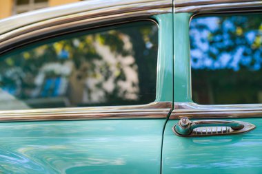 Mavi ve beyaz eski model araba kapılardan