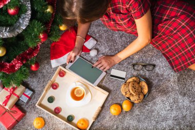 Tablet ile kredi kartı yerde yatarken ve boşluk tutan kadın. Noel alışveriş kavramı