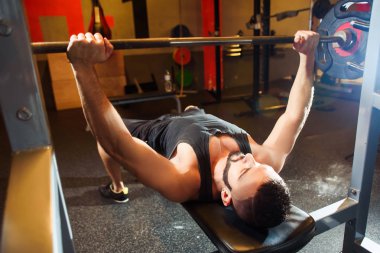 Bench Press göğsüne egzersiz spor salonunda genç adam