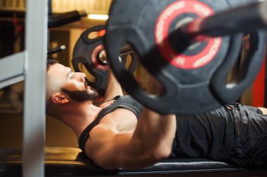 Bench Press göğsüne egzersiz spor salonunda genç adam