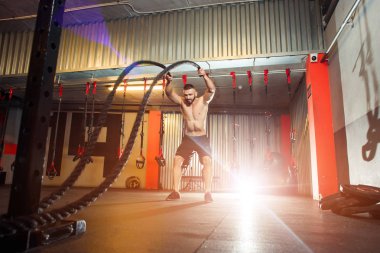 Genç adam birlikte savaş ipler fitness salonunda egzersiz yerleştirmek