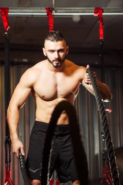 Genç adam birlikte savaş ipler fitness salonunda egzersiz yerleştirmek