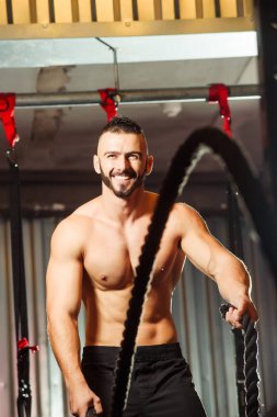 Genç adam birlikte savaş ipler fitness salonunda egzersiz yerleştirmek