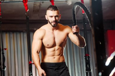 Genç adam birlikte savaş ipler fitness salonunda egzersiz yerleştirmek