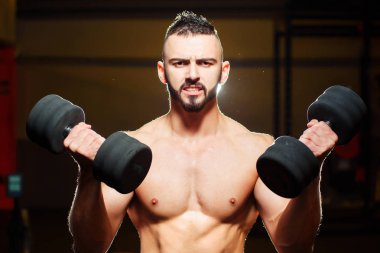 Kas gömleksiz genç adam halter salonunda holding