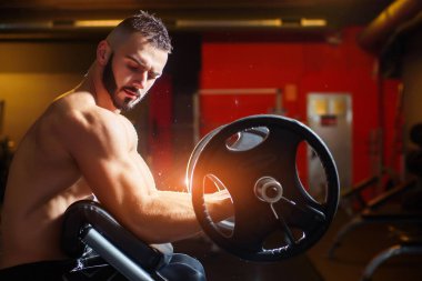 Barbell ile eğitim ve pazı arayan genç kaslı adam 