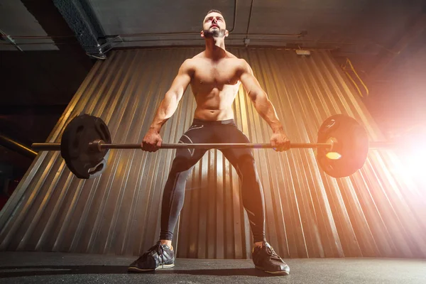 Muscular jovem fazendo deadlift com sinos no ginásio — Fotografia de Stock