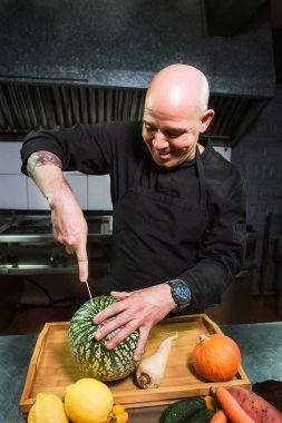 Genç erkek Şef mutfak beyaz karpuz kesme