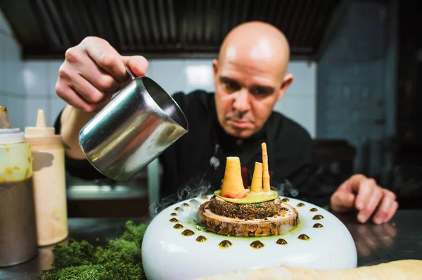 Young chef preparing modern molecular dish with liquid nitrogen