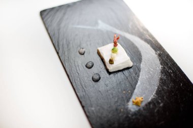 Karanlık bir arka plan üzerinde izole bir tabak içinde modern bir moleküler yemek Close-Up