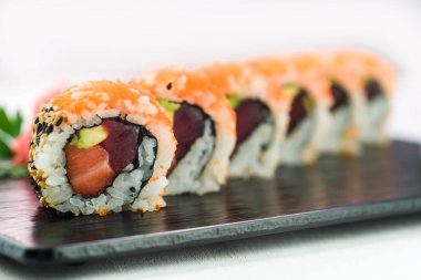 Rulo ve suşi siyah bir taş plaka üzerinde