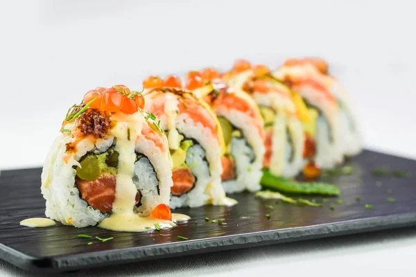 Primer plano de rollos tradicionales japoneses y sushi en un plato de piedra negro — Foto de Stock