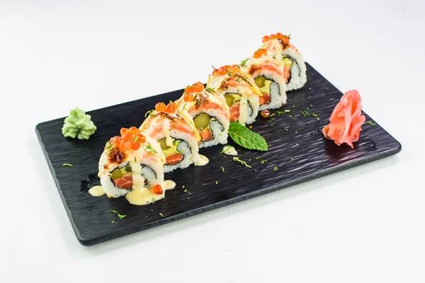 Rollos y sushi en un plato de piedra negra. Vista superior — Foto de Stock