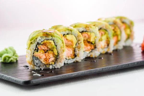 Rollo de sushi cubierto con aguacate — Foto de Stock