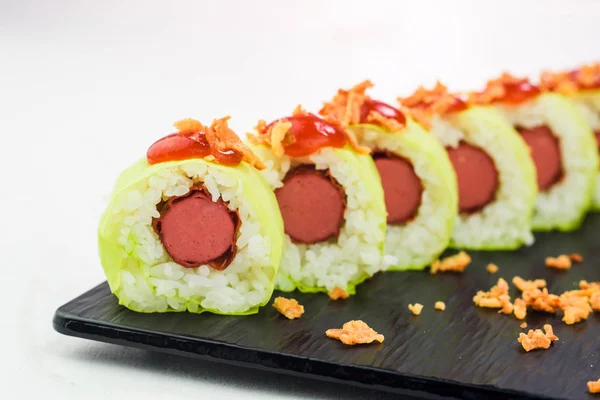 Sushi rolls of sausage covered with cabbage. Homemade asian style.