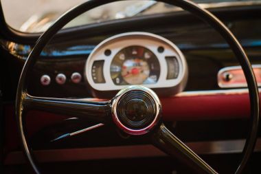 Direksiyon simidi ve dashboard-eski model bir araba kırmızı deri iç in close-up. Klasik retromobile Ayrıntılar.