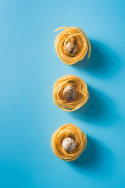 Bıldırcın yumurta üzerinde izole mavi arka plan iç içe