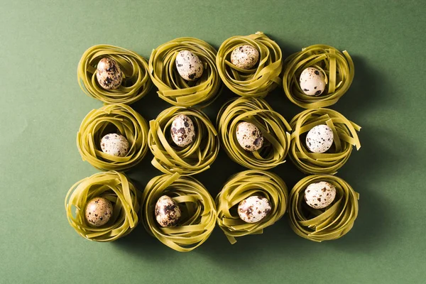 Kwartel eieren in spinazie pasta nesten op groene achtergrond — Stockfoto