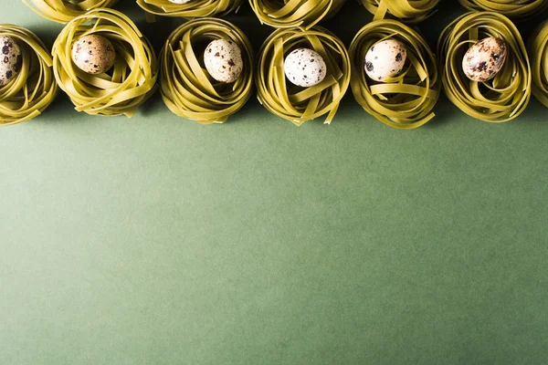 Kwartel eieren in spinazie pasta nesten op groene achtergrond — Stockfoto