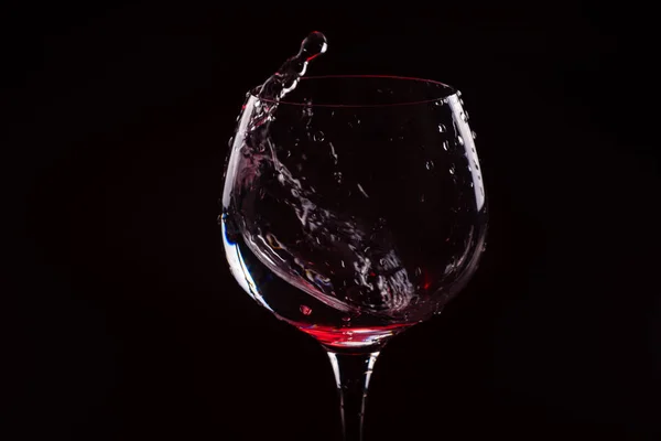 Vin rouge éclaboussant d'un grand verre à vin — Photo