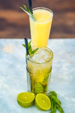 Beyaz bir masada pinina colada ve mojito alkollü kokteyller..