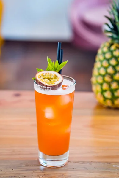 Close-up of passion fruit hurricane fresh cocktail in a tall glass at bar background. — Stockfoto