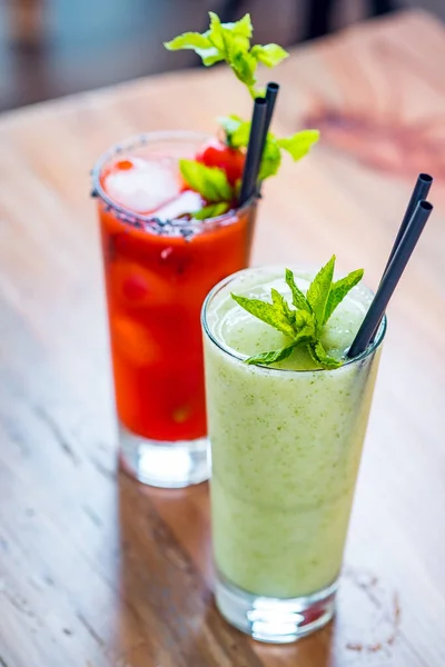 Αντίθεση εικόνα της αιματηρής κοκτέιλ κοκτέιλ αλκοολούχο ποτό και πράσινο υγιεινό smoothie μέντα. — Φωτογραφία Αρχείου