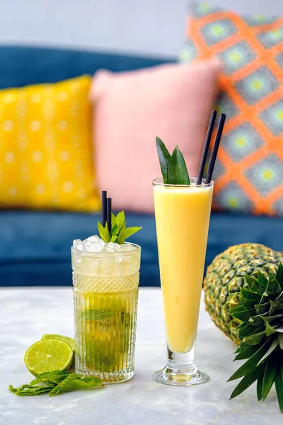 Close-up van pina colada en mojito alcoholische cocktails op een witte tafel. — Stockfoto