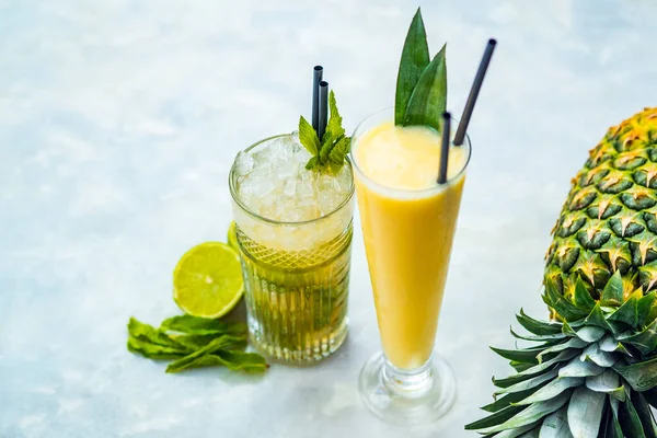 Close-up de pina colada e coquetéis alcoólicos mojito em uma mesa branca . — Fotografia de Stock