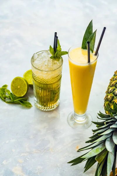 Close-up de pina colada e coquetéis alcoólicos mojito em uma mesa branca . — Fotografia de Stock