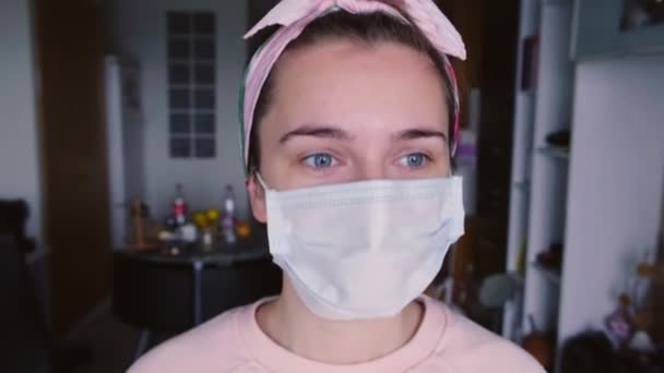 医療保護マスクの若い女性のスローモーションは ウィンドウに向かって行くし 悲しい感じに背を向ける コロナウイルス隔離の概念 Covid — ストック動画