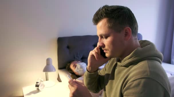 Hombre Preocupado Mirando Termómetro Llamando Médico Para Obtener Instrucciones Esposa — Vídeo de stock