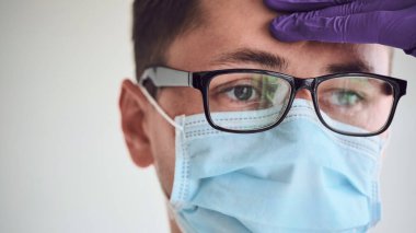 Tıbbi maskeli, sisli gözlüklü ve bertaraf eldivenli genç doktorların yakın çekimi. Coronavirus, Covid-19, 2019-NCoV salgını. Tıbbi sistem çöktü. Karantina, evde kal. Boşluğu kopyala.