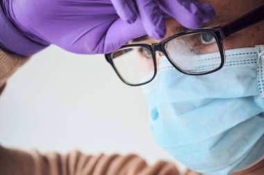 Tıbbi maskeli, sisli gözlüklü ve bertaraf eldivenli genç doktorların yakın çekimi. Coronavirus, Covid-19, 2019-NCoV salgını. Tıbbi sistem çöktü. Karantina, evde kal. Boşluğu kopyala.