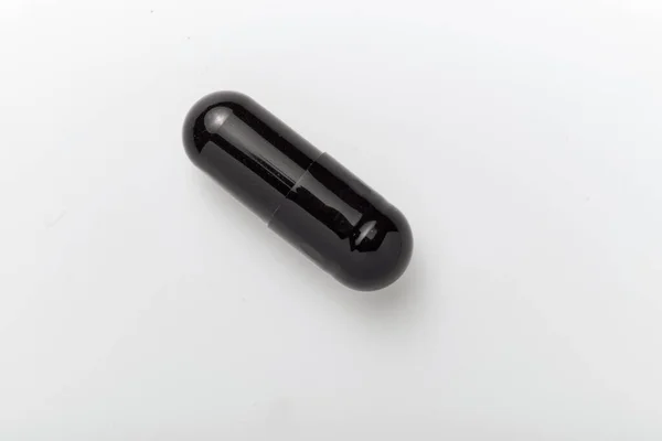 Gros Plan Capsule Noire Isolée Sur Fond Blanc Macro Concept — Photo