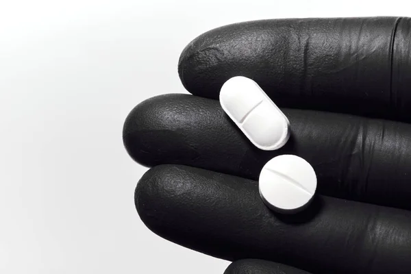 Close Mão Luva Látex Preto Segurando Pílulas Brancas Médico Mão — Fotografia de Stock