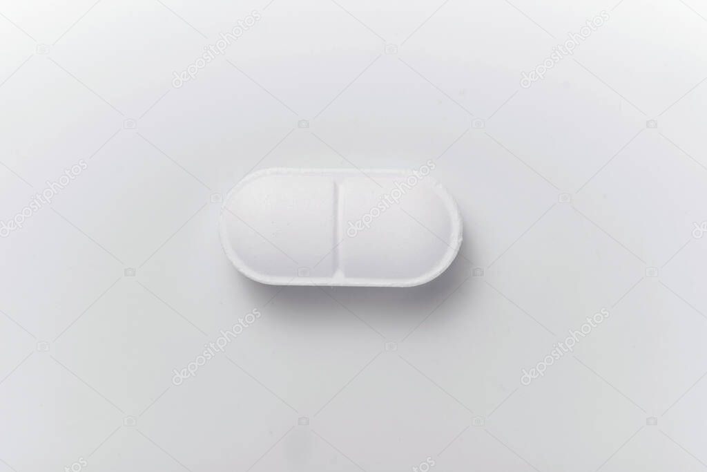 Close-up of white pill isolated on white background. Macro. Medicine concept. Antivirus treatment.