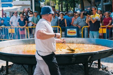 İspanya Denia 10 Ekim 2019. Aşçılar sokakta büyük bir paella valencian pişiriyor.